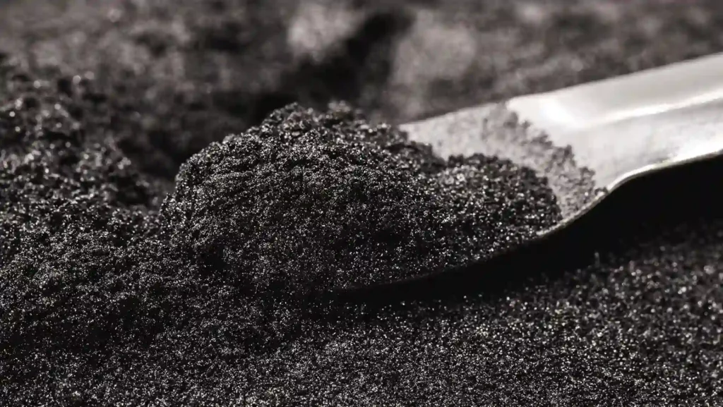 Chrome ore concentrate on a metal scoop
